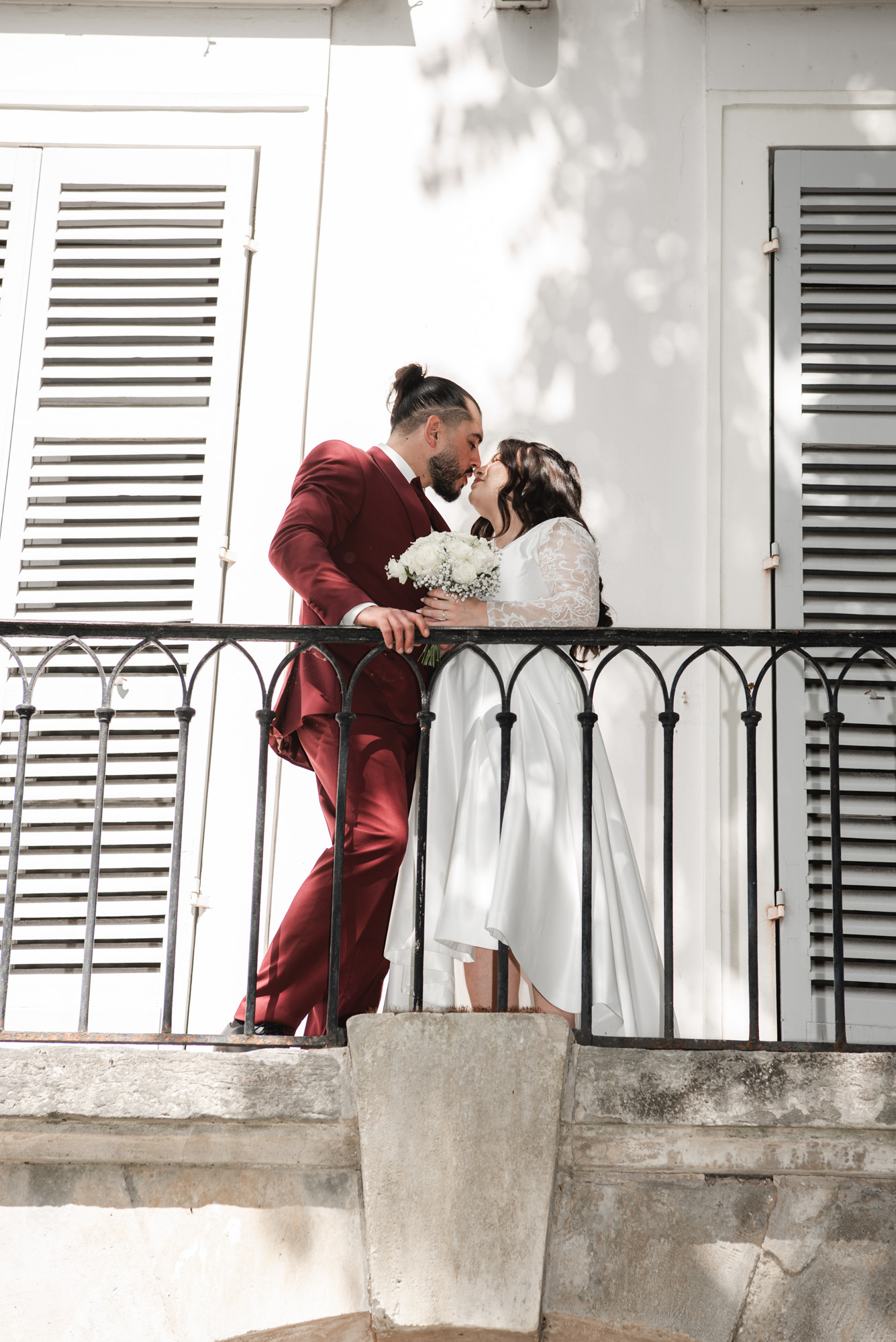 Les mariés s’embrassent sur un balcon après leur mariage civil en Île-de-France